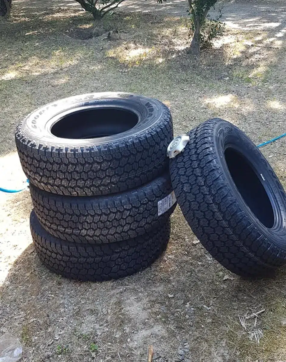 Quatre pneus tout-terrain empilés sur l'herbe